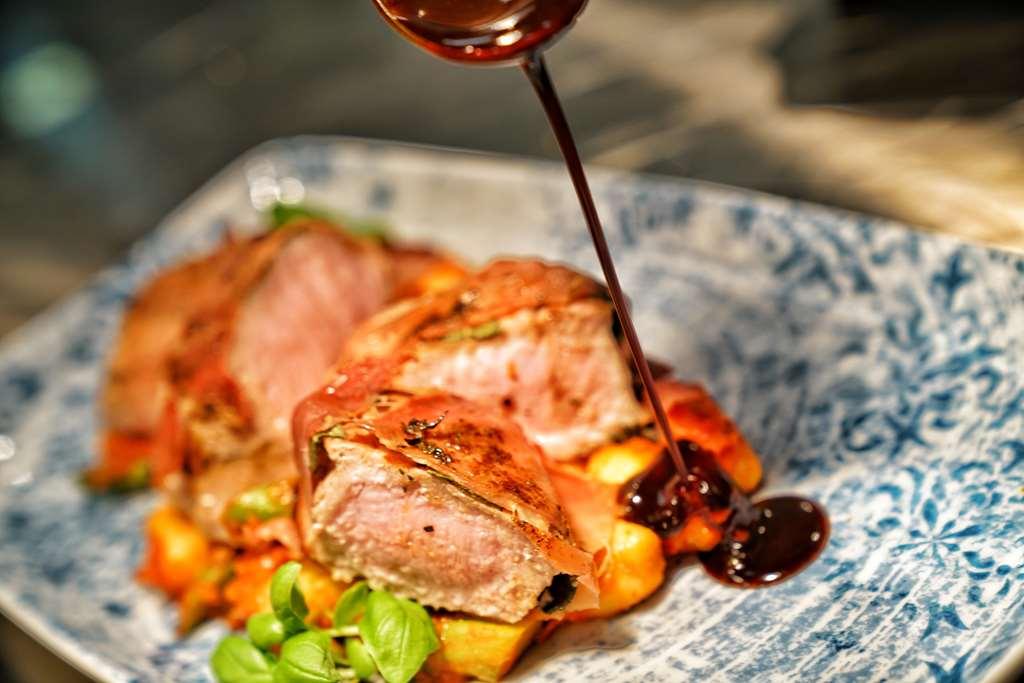 Vila Vita Rosenpark 마르부르크 외부 사진 A meat dish being drizzled with a sauce